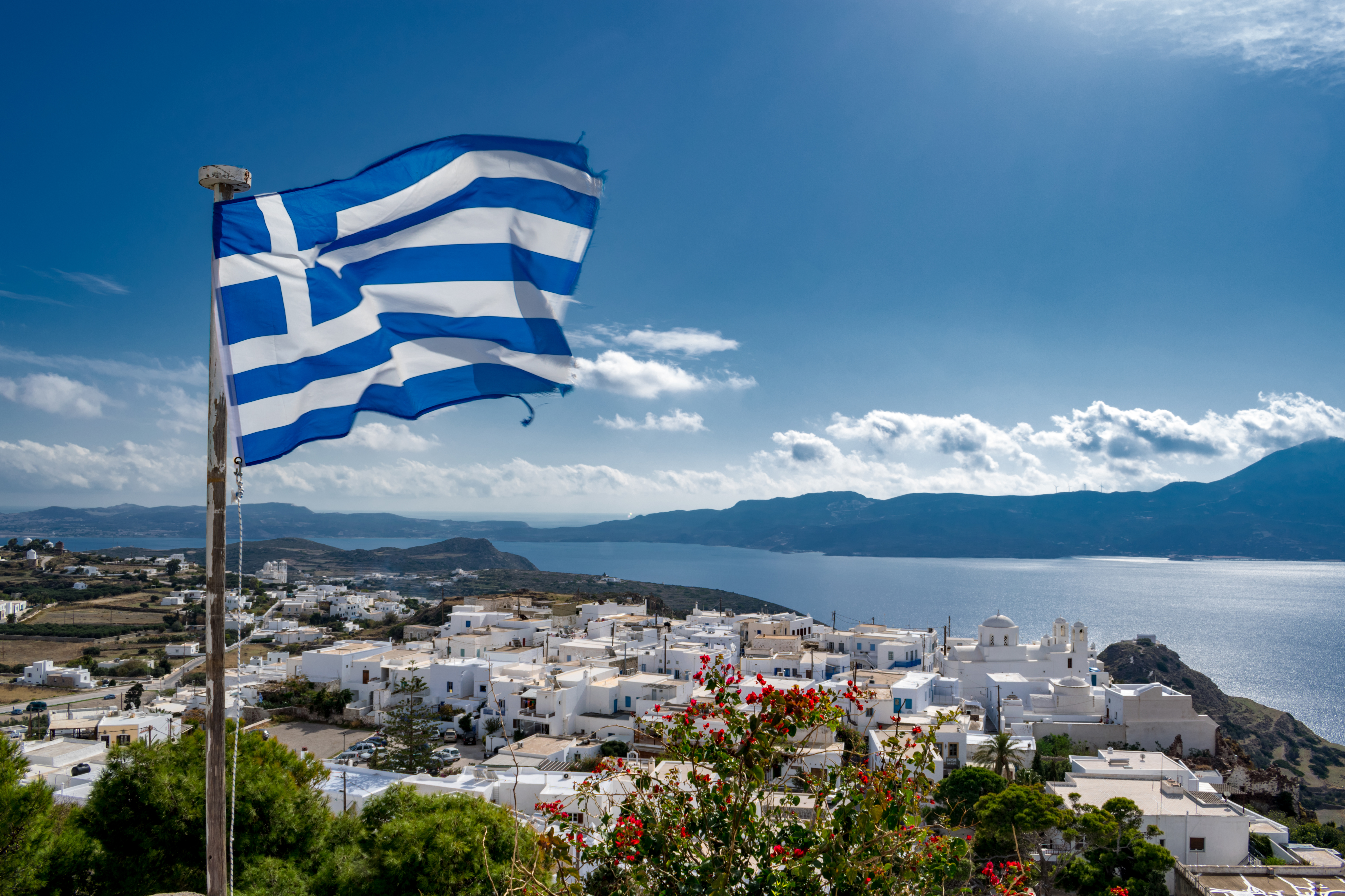 Flag on the background of the city of Greece, where the law on immigration by investment was amended