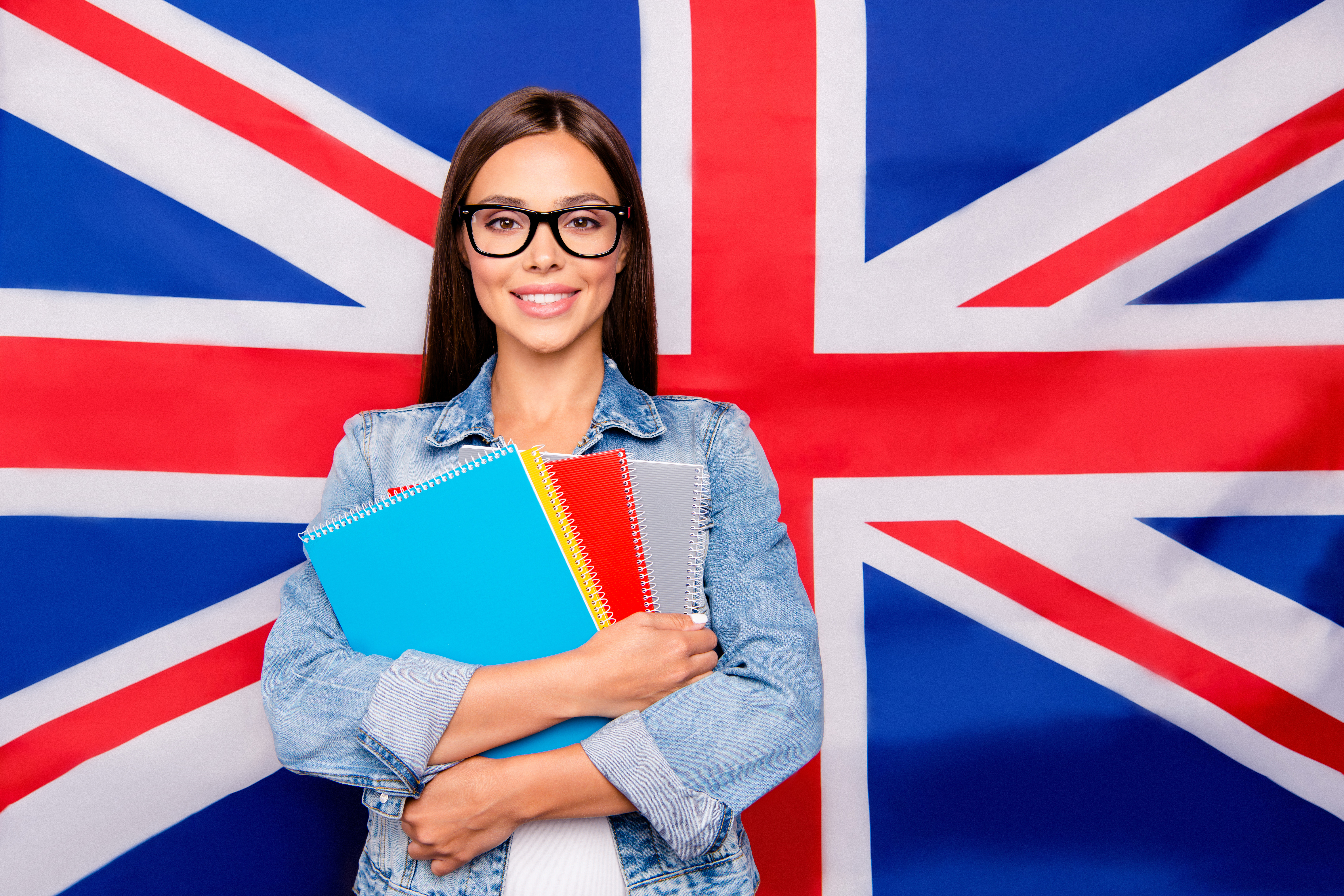 A visa for talented professionals of Great Britain has been opened for a girl with notebooks against the background of the British flag